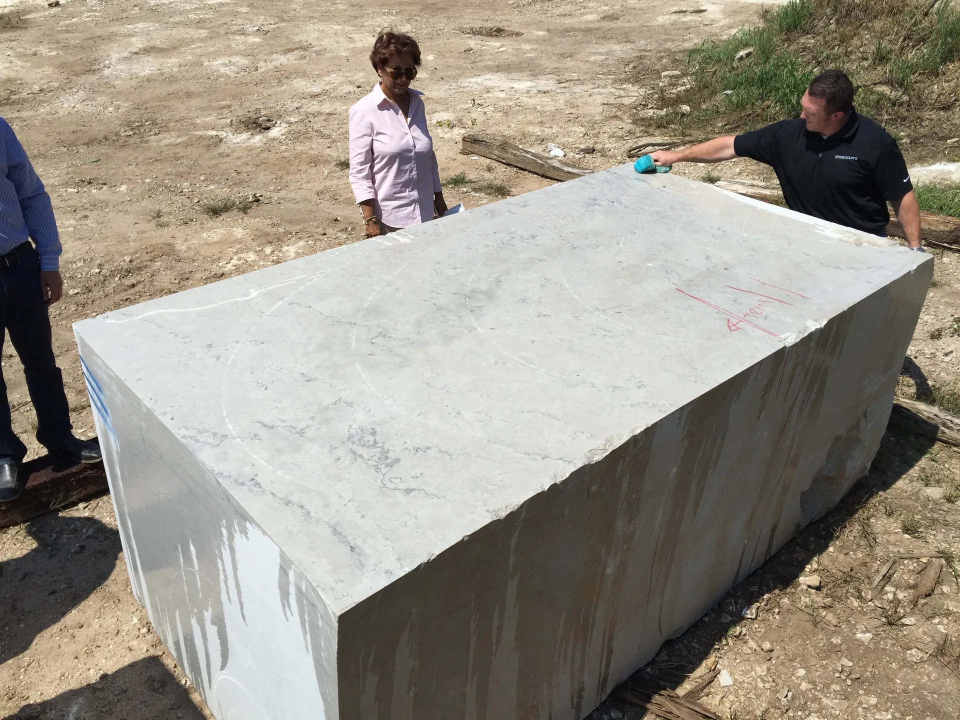 Rupy Shah inspecting a stone block prior to cutting, making sure it's the best available