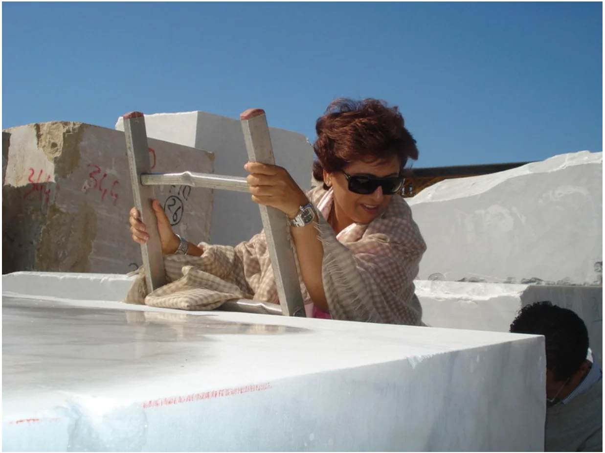 Rupy Shah climbing to inspect a stone block at the quarry